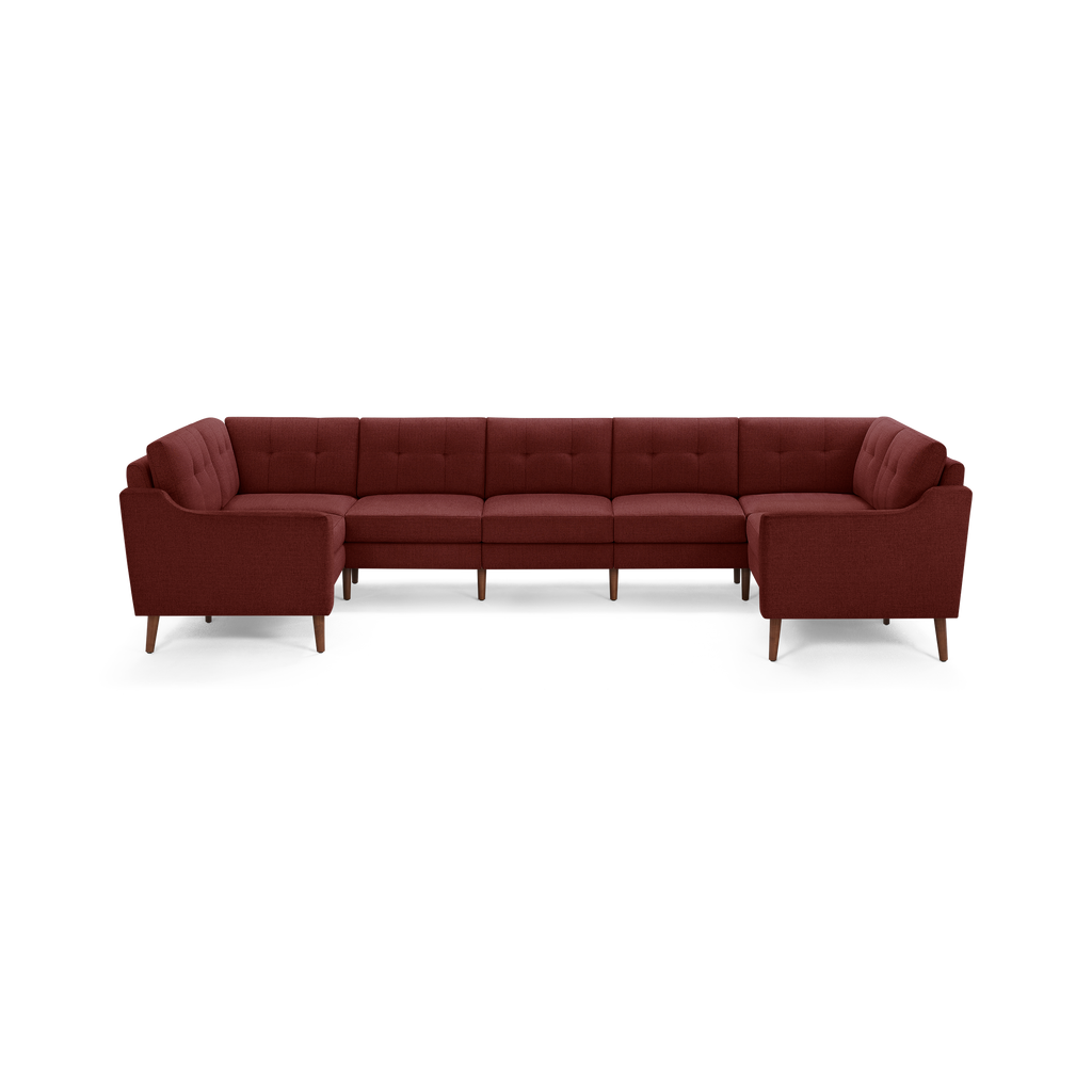 Large L-shaped sectional sofa with mid-century design, tufted cushions, and wooden tapered legs in dark red upholstery.