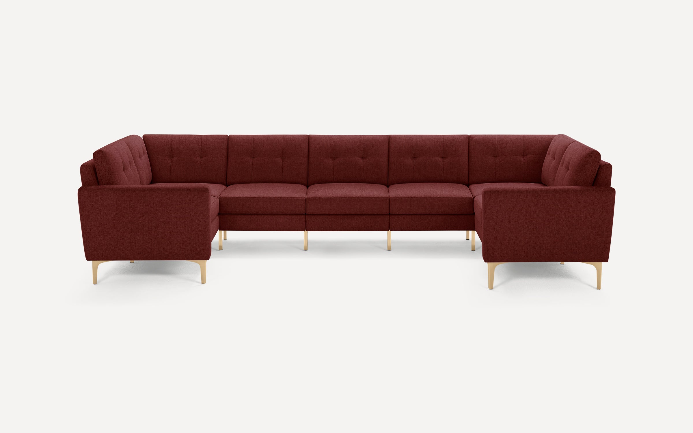 Large modern burgundy fabric sectional sofa with tufted cushions and light wooden legs, arranged in a U-shape.