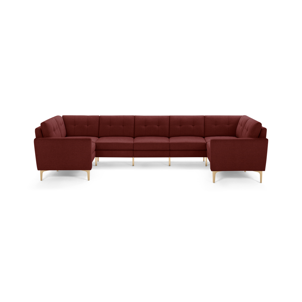 Large U-shaped sectional sofa in deep red fabric with tufted back cushions and light wooden legs, modern design.