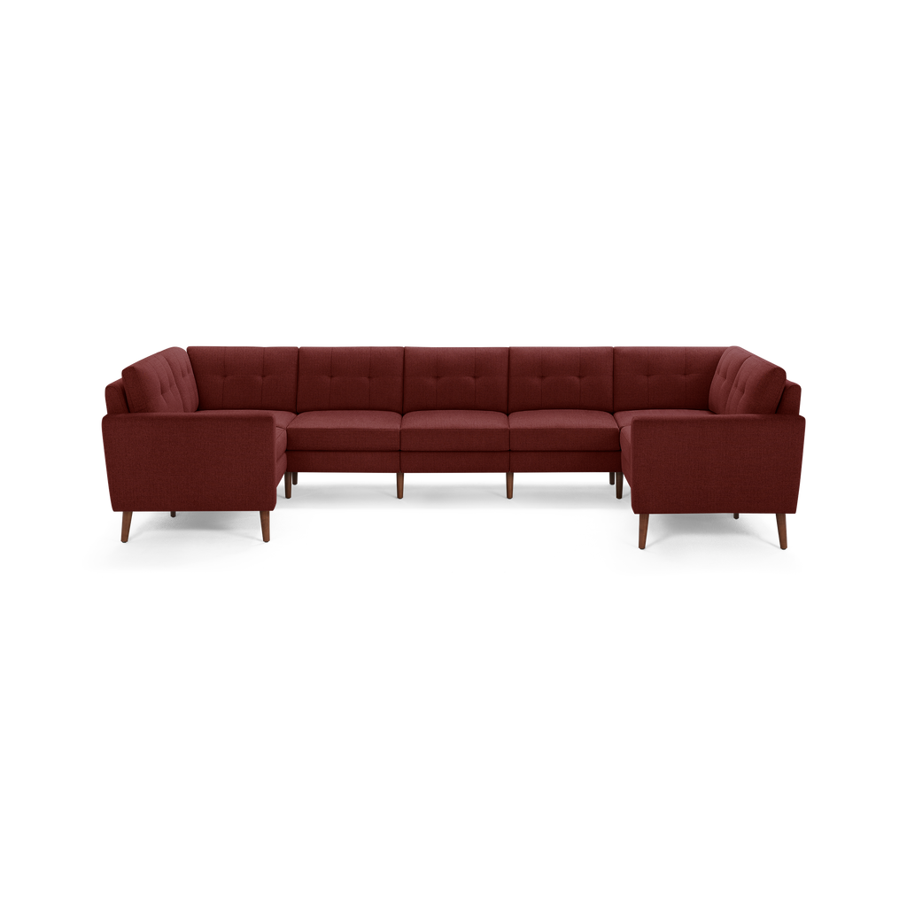 Large U-shaped sectional sofa upholstered in deep red fabric with tufted back cushions and wooden tapered legs.
