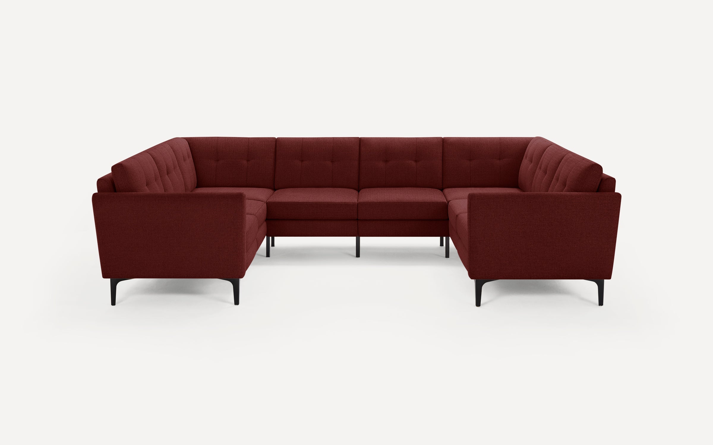 Modern U-shaped sectional sofa in dark red fabric with tufted cushions and black metal legs on a white background.