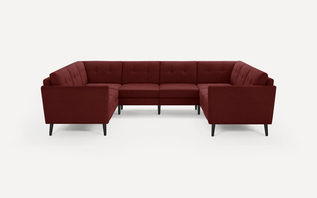 Maroon fabric sectional sofa with tufted backrests and straight armrests, supported by slim black tapered legs.
