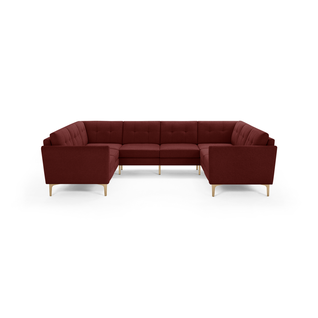 Spacious L-shaped sectional sofa in deep burgundy fabric with tufted cushions and light wooden legs, offering modern comfort and style.