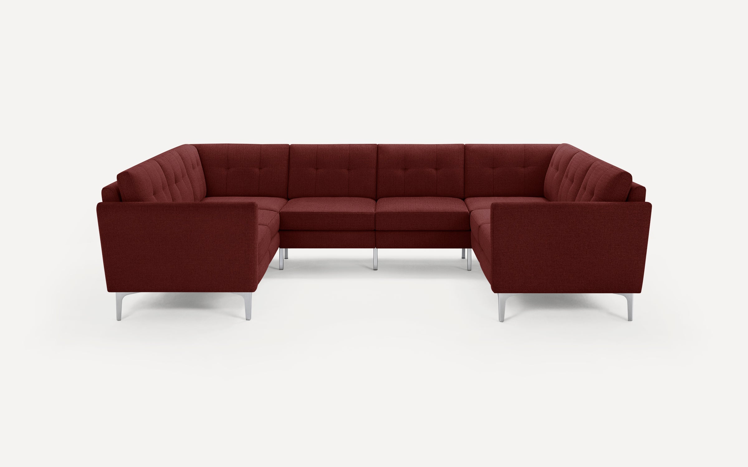Large U-shaped sectional sofa upholstered in textured dark red fabric with tufted back cushions and slim metal legs.