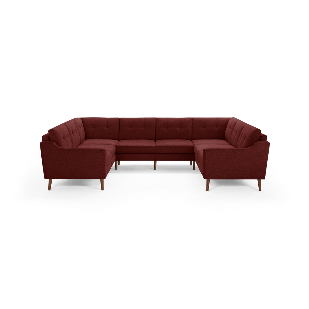 Mid-century modern U-shaped sectional sofa in deep red fabric with tufted back cushions and wooden legs.