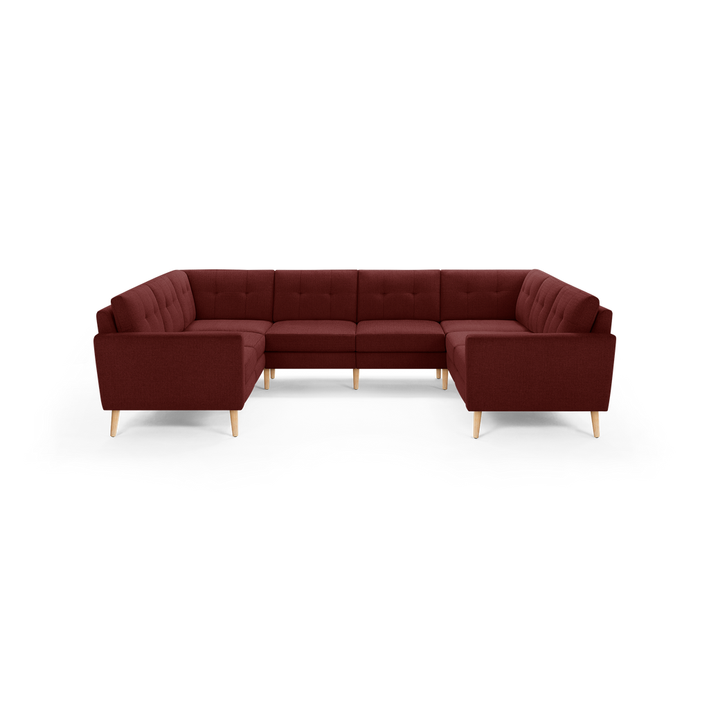 U-shaped sectional sofa in deep burgundy fabric with tufted back cushions and light wooden tapered legs, modern and spacious design.