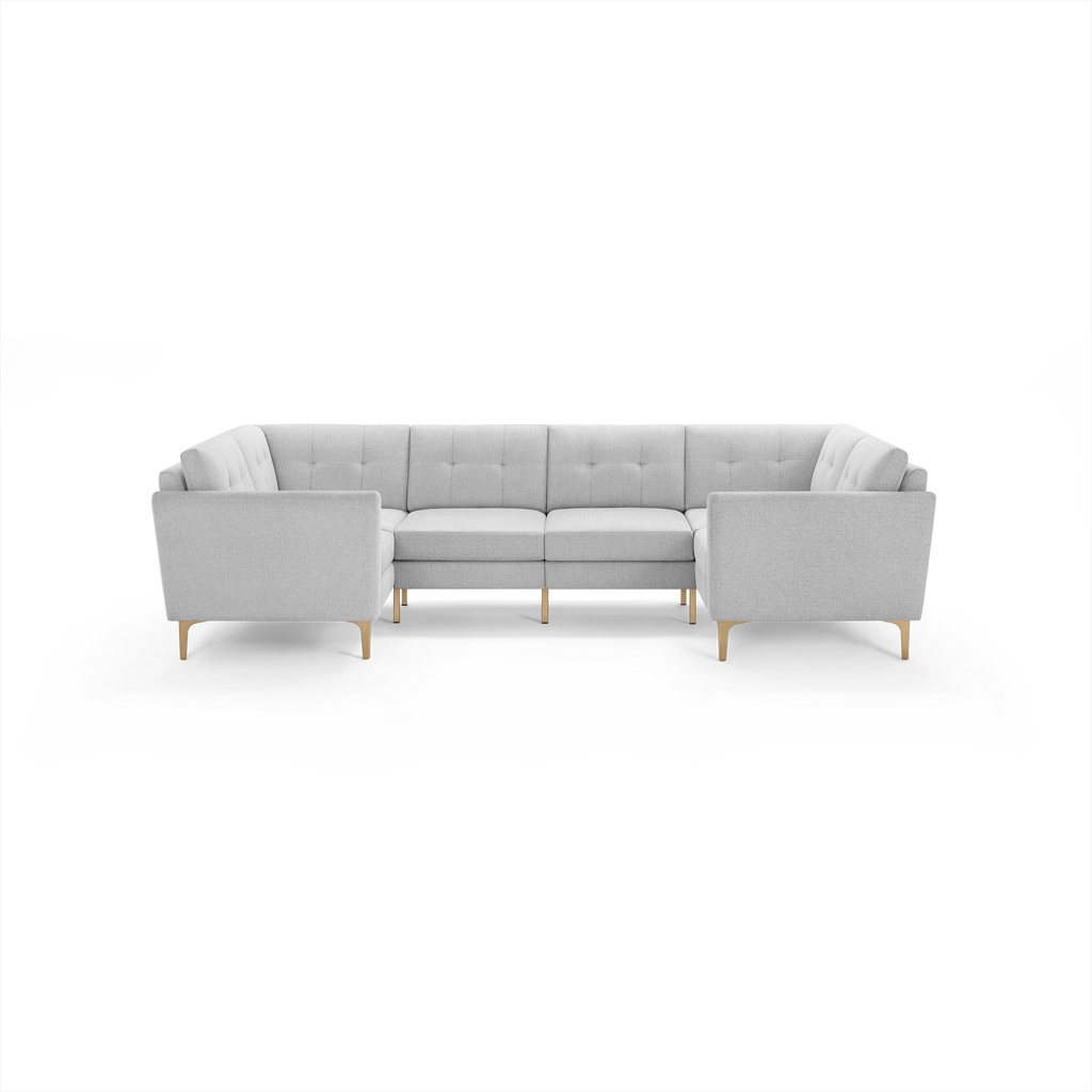 Light gray upholstered U-shaped sectional sofa with tufted cushions and wooden legs, designed for spacious seating and modern living rooms.