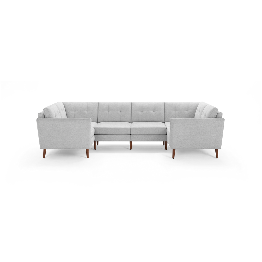 Light gray fabric upholstered U-shaped sectional sofa with tufted back cushions and wooden legs.