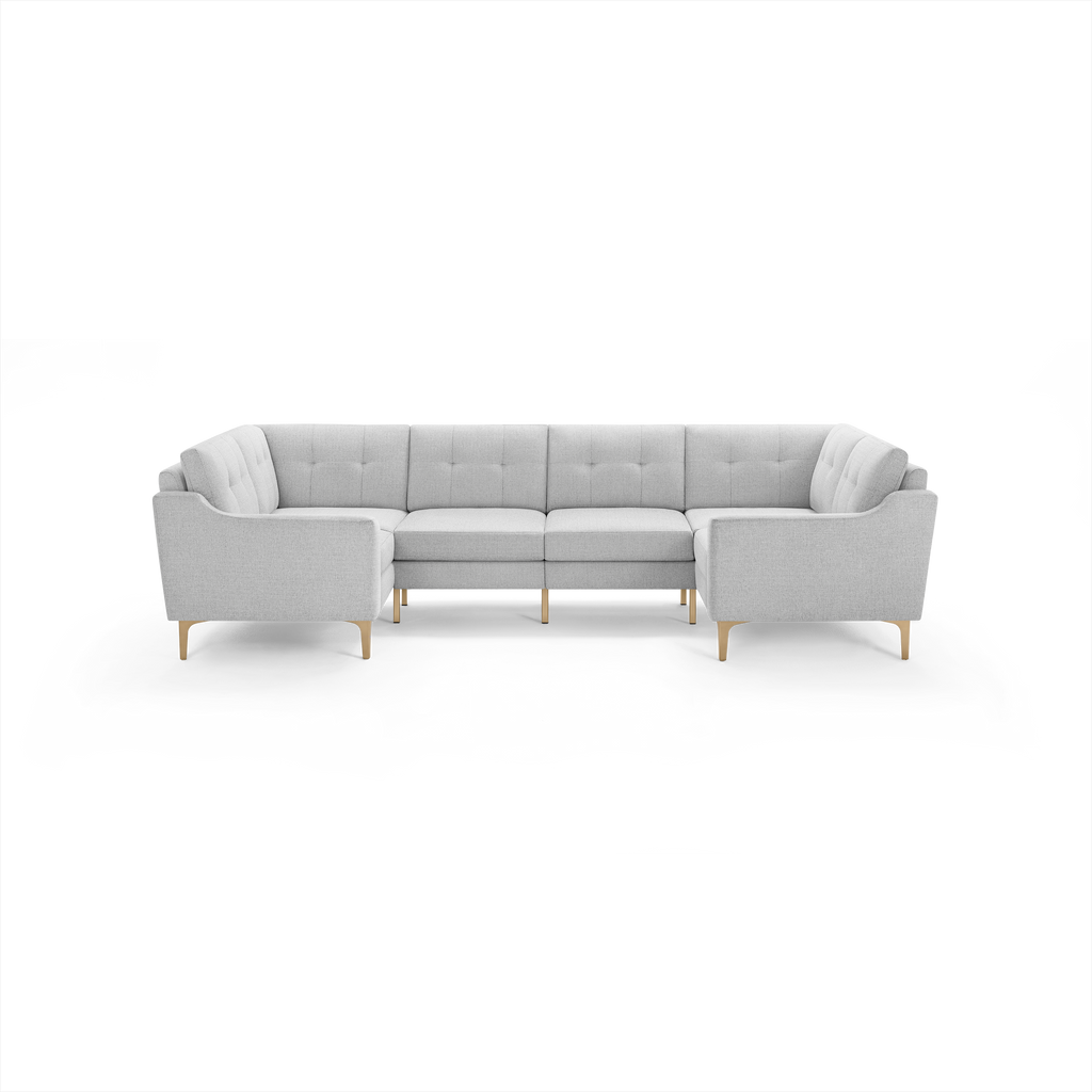 Light gray fabric U-shaped sectional sofa with tufted cushions and wooden legs, modern and spacious for living room seating.