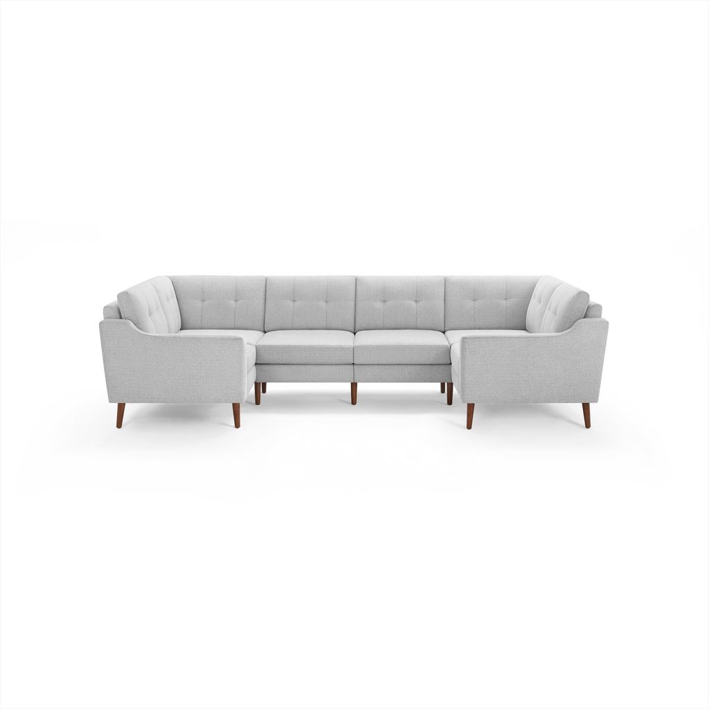 Light gray fabric U-shaped sectional sofa with tufted back cushions and wooden legs.