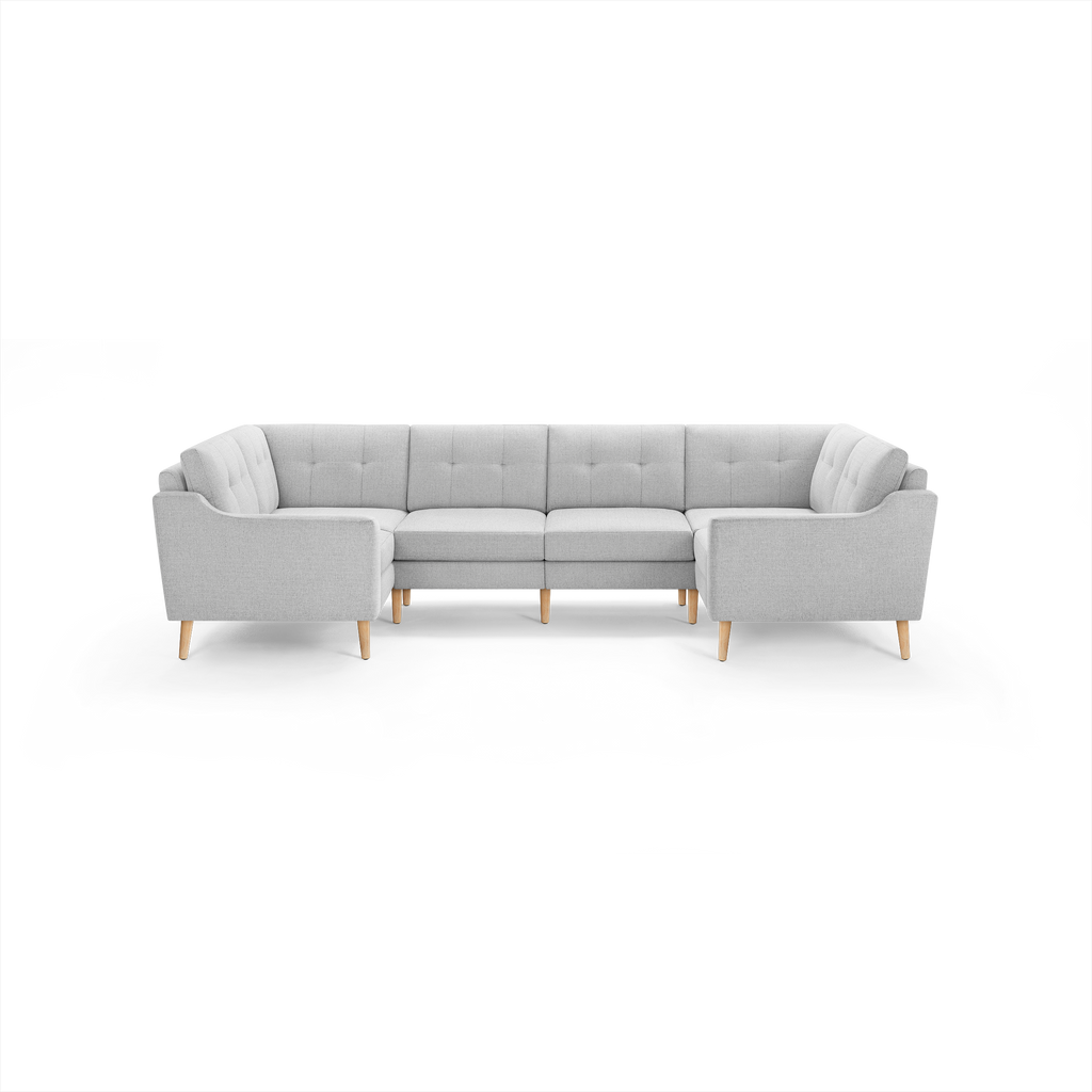 Light gray L-shaped sectional sofa with tufted cushions and wooden legs, featuring rounded armrests and modern design.