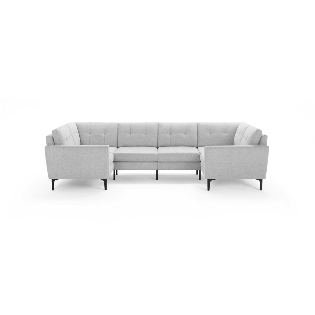 Light gray upholstered U-shaped sectional sofa with tufted back cushions and slim black metal legs, designed for modern living rooms.