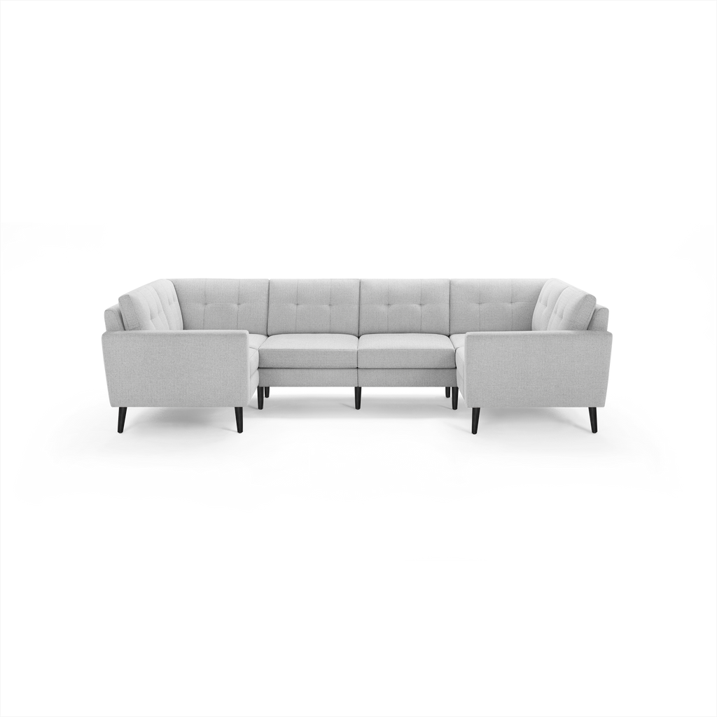 Light gray fabric U-shaped sectional sofa with tufted cushions and black wooden legs on a black background.
