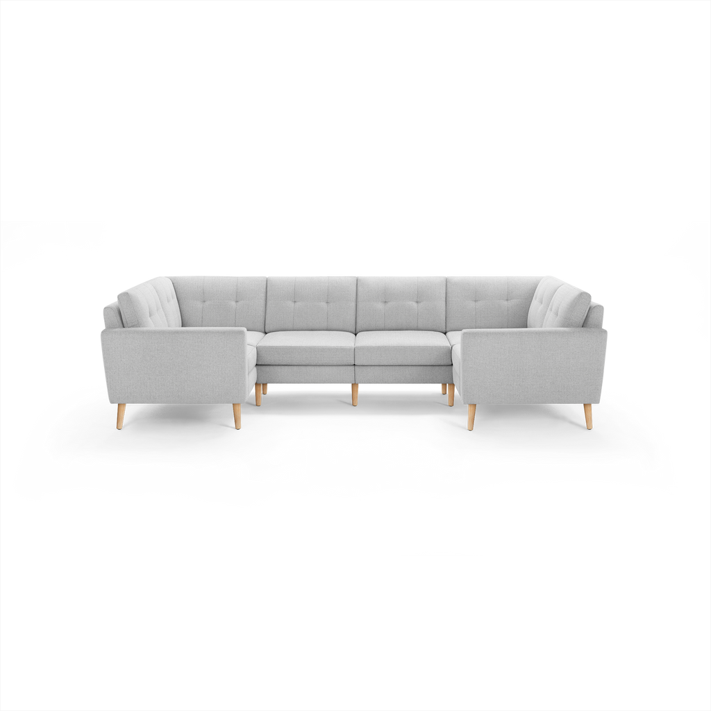 Light gray L-shaped sectional sofa with tufted back cushions and wooden legs, designed for spacious seating and modern decor.