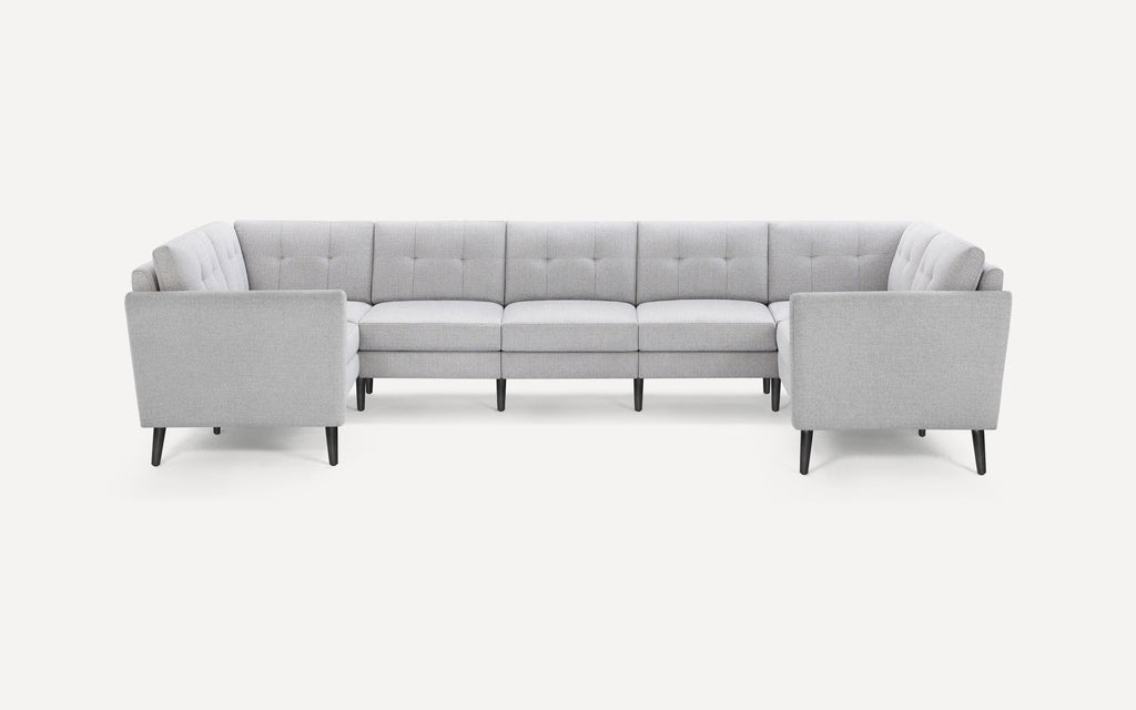 Light gray U-shaped sectional sofa with tufted back cushions and tapered black wooden legs on a white background.