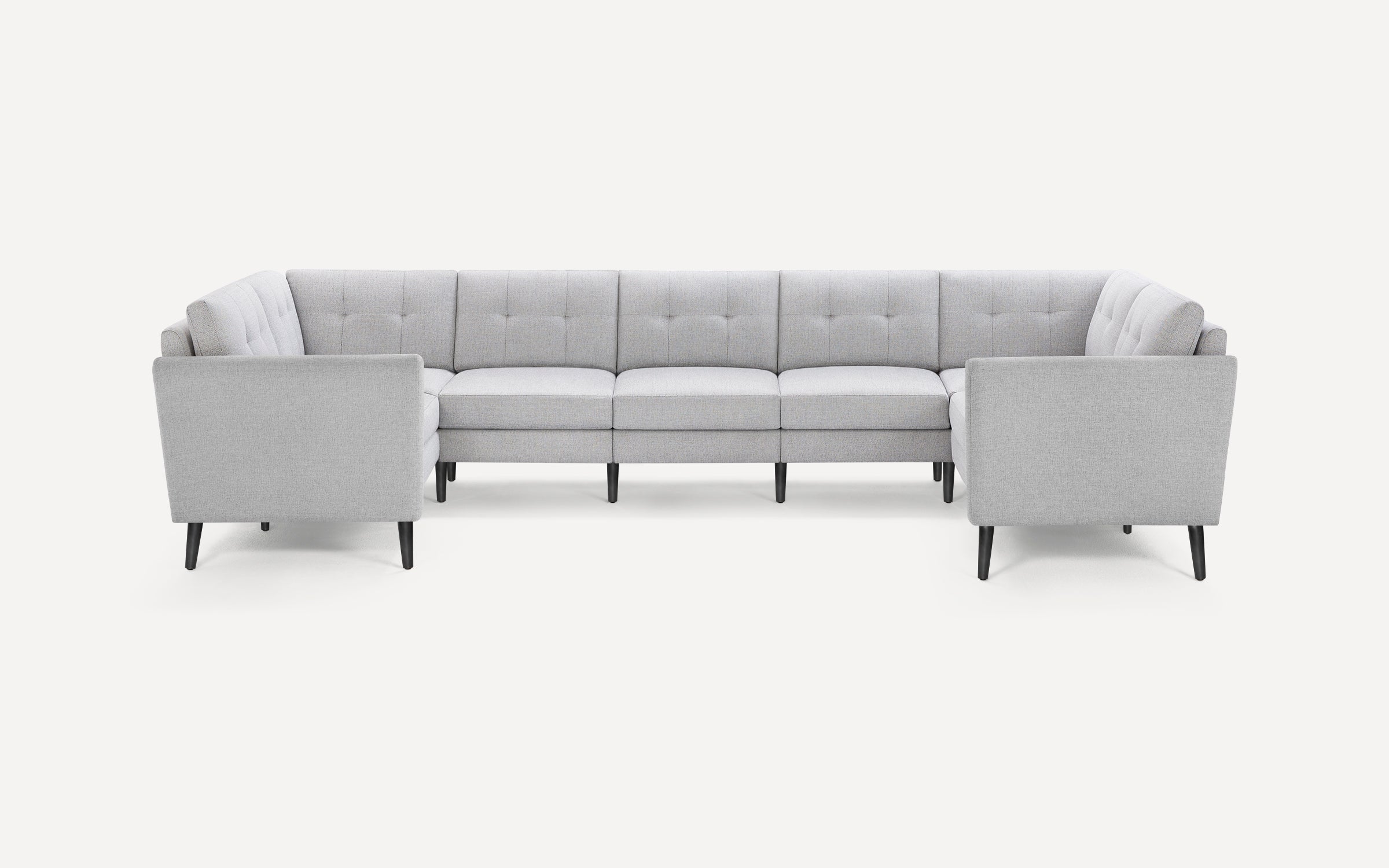 Light gray U-shaped sectional sofa with tufted back cushions and tapered black wooden legs on a white background.