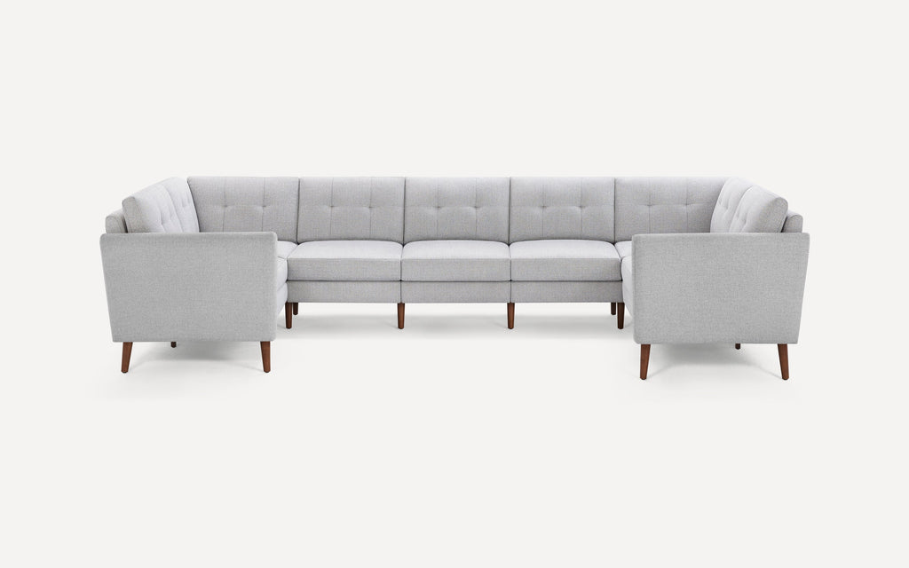 Light gray, mid-century modern U-shaped sectional sofa with tufted back cushions and wooden tapered legs on white background.