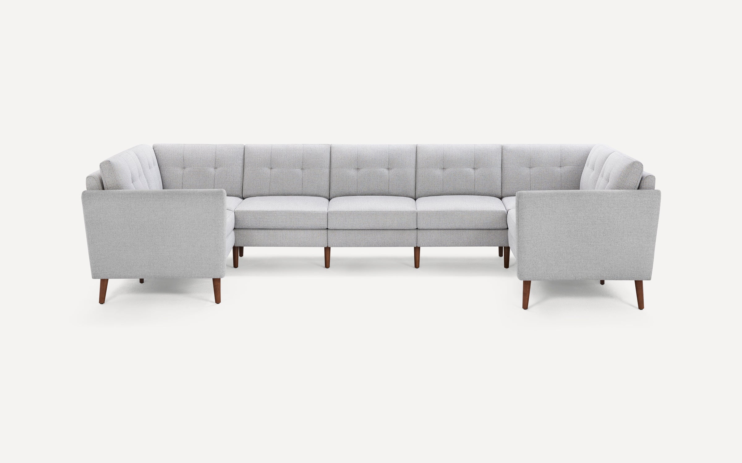 Light gray, mid-century modern U-shaped sectional sofa with tufted back cushions and wooden tapered legs on white background.