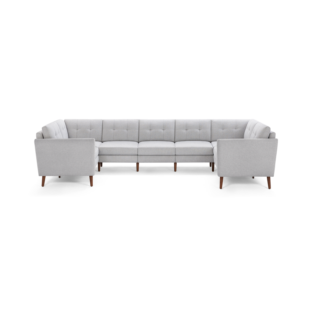 Light gray upholstered L-shaped sectional sofa with tufted back cushions and tapered wooden legs.