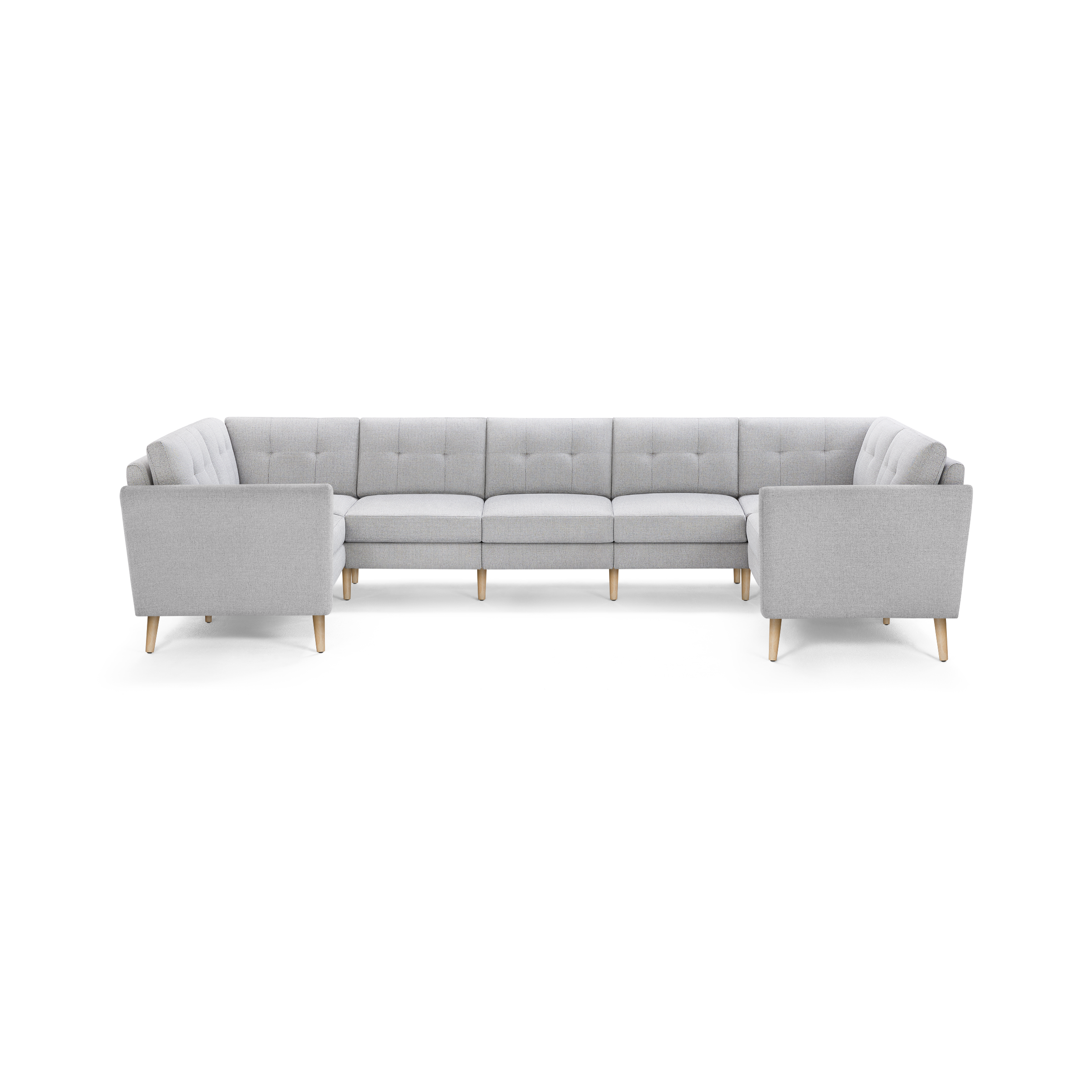 Light gray upholstered U-shaped sectional sofa with tufted back cushions and light wood tapered legs.