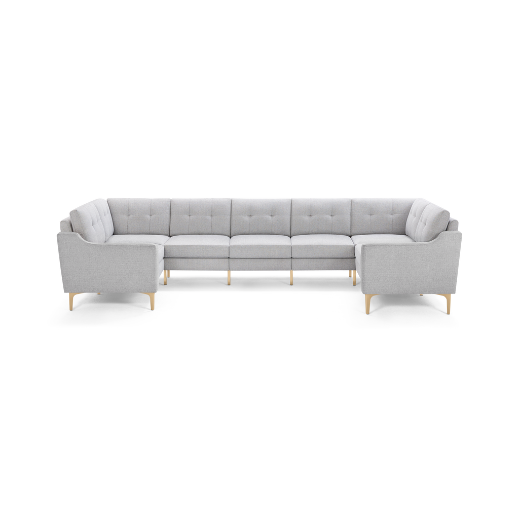 Light gray modern sectional sofa with tufted back cushions and wooden legs, designed in a U-shape for ample seating.