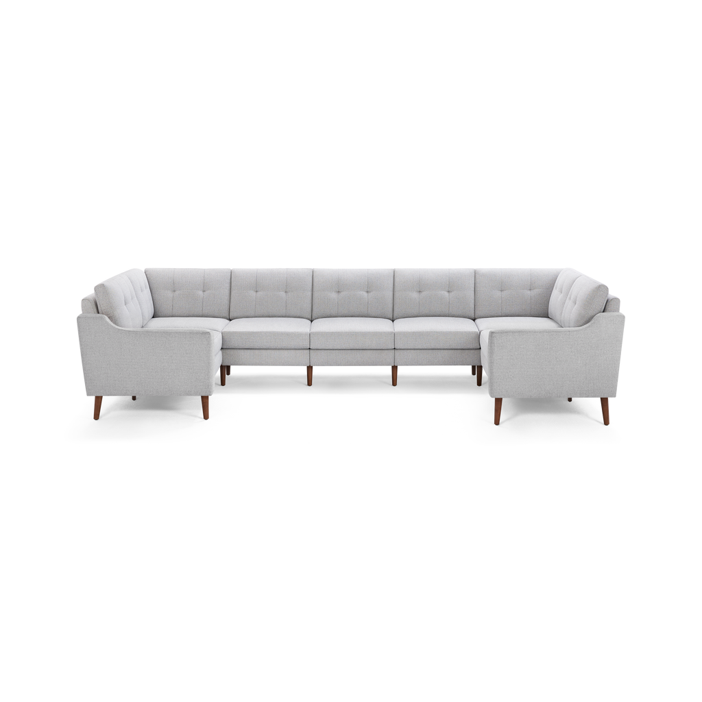 Light gray upholstered U-shaped sectional sofa with tufted back cushions and wooden legs, designed for modern living rooms.