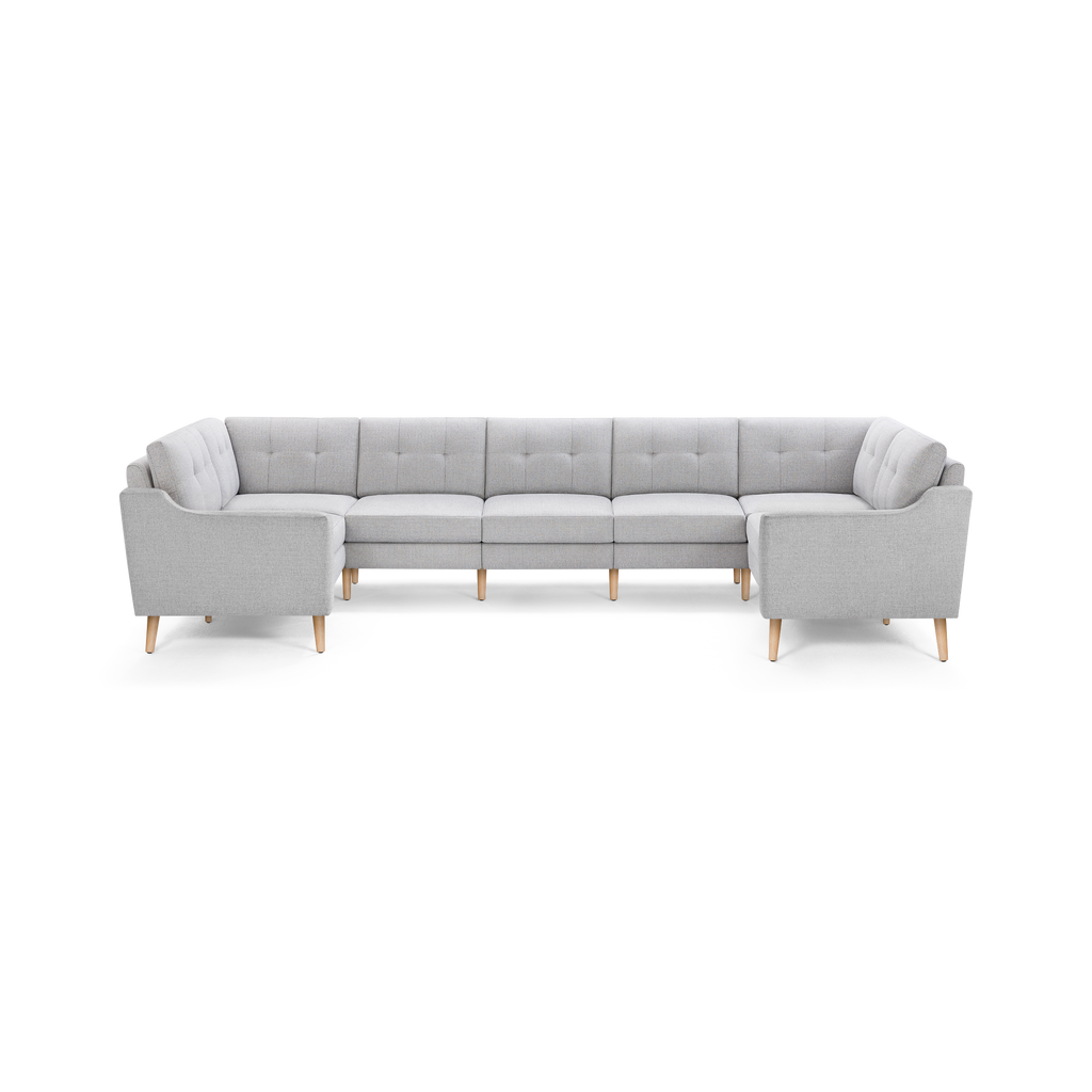 Light gray L-shaped sectional sofa with tufted cushions and wooden legs, modern and spacious for large living rooms.