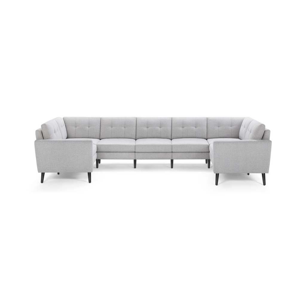 Light gray fabric sectional sofa with tufted back cushions, straight arms, and black tapered legs, designed for spacious seating.