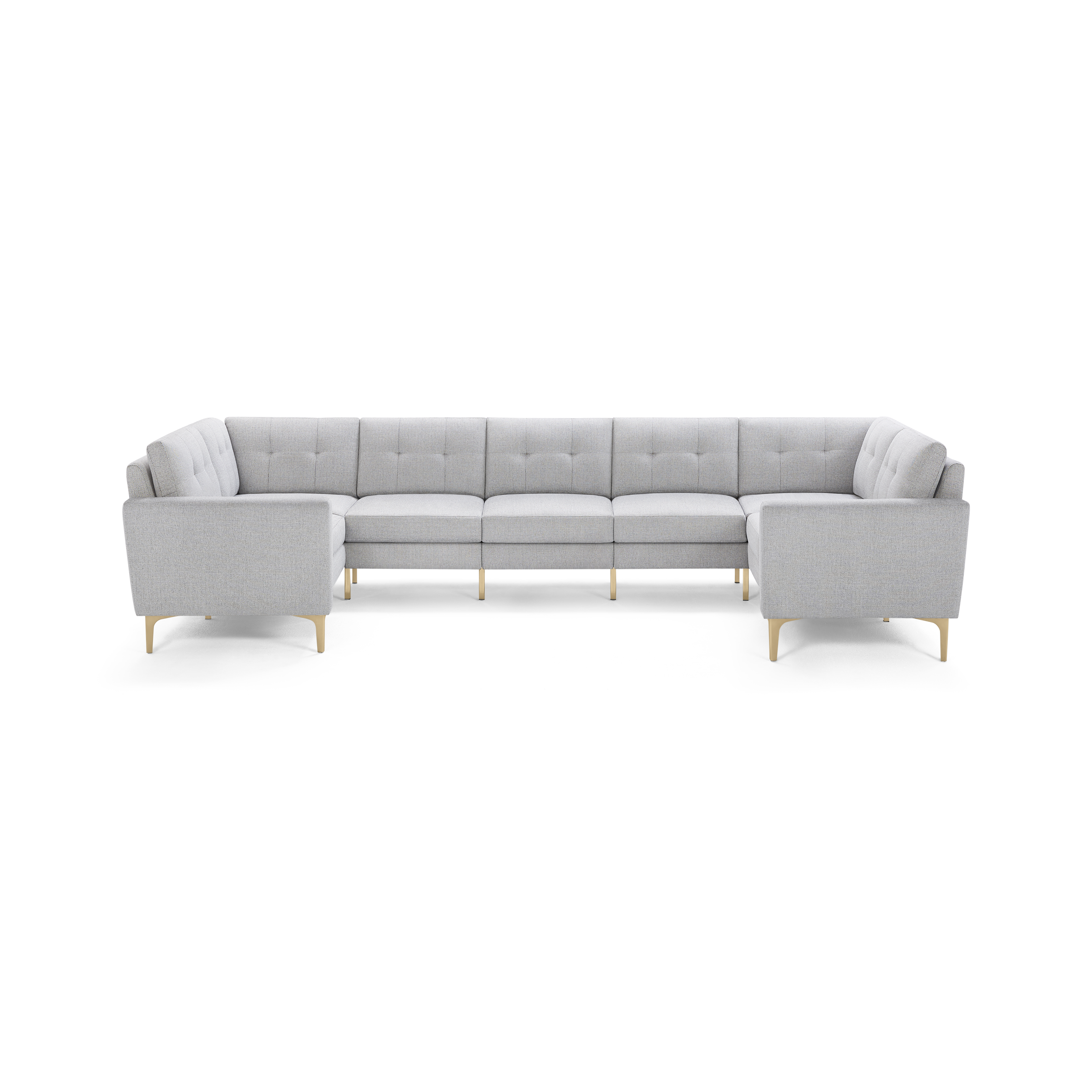 Large light gray upholstered sectional sofa with tufted cushions and light wooden legs, arranged in a spacious U-shape.