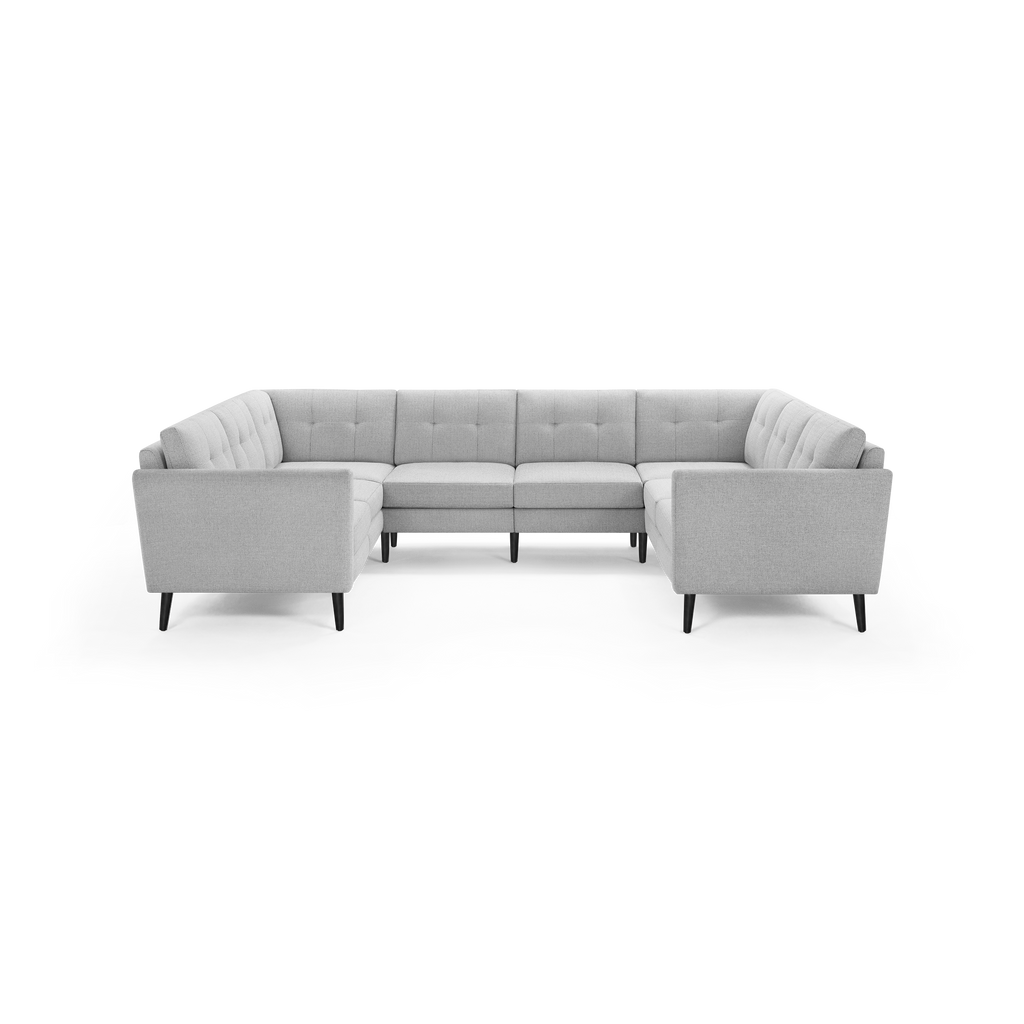 Light gray L-shaped sectional sofa with tufted back cushions, square arms, and dark wooden legs on black background.