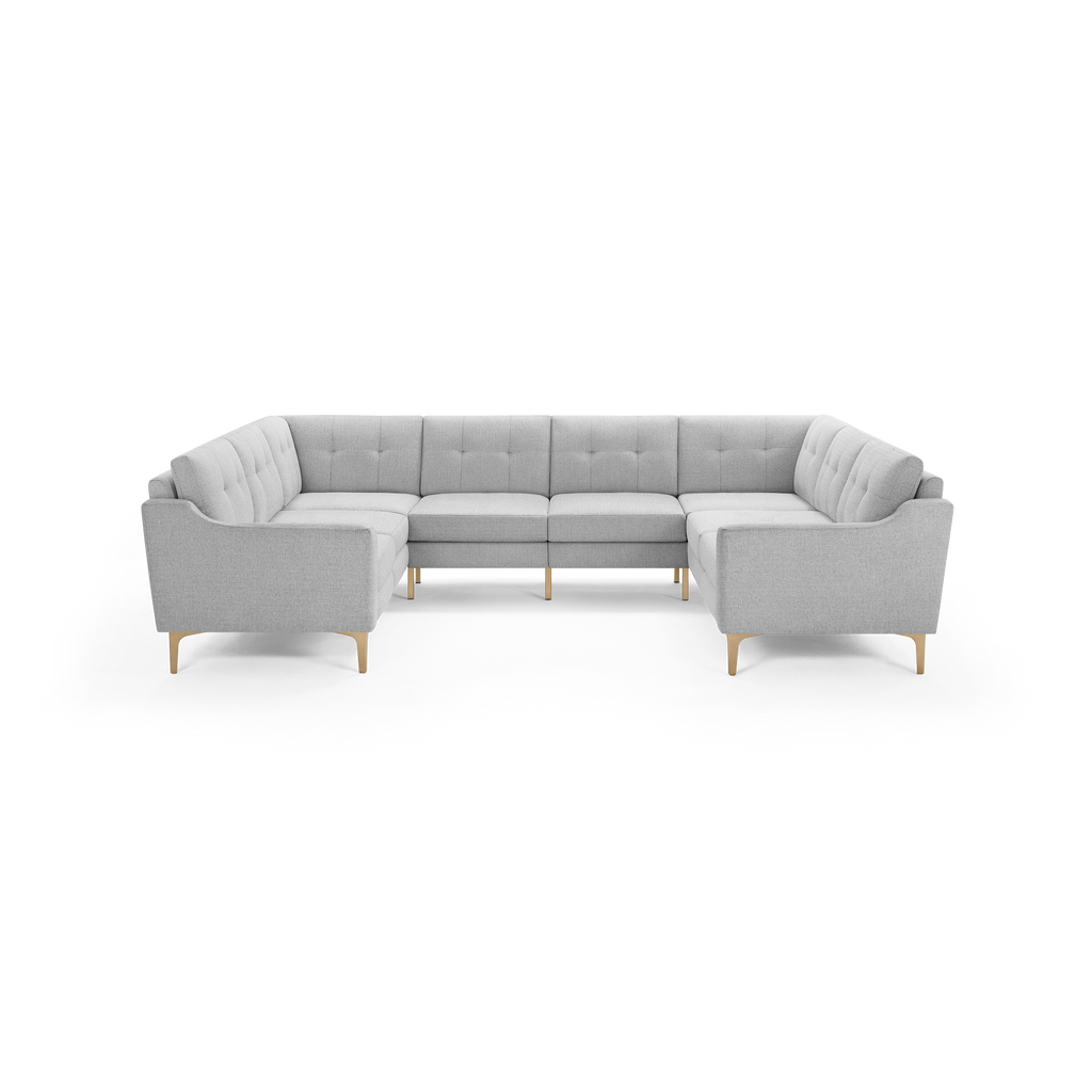 Light gray, tufted fabric sectional sofa with wooden legs, featuring a modern, clean-lined U-shaped design.