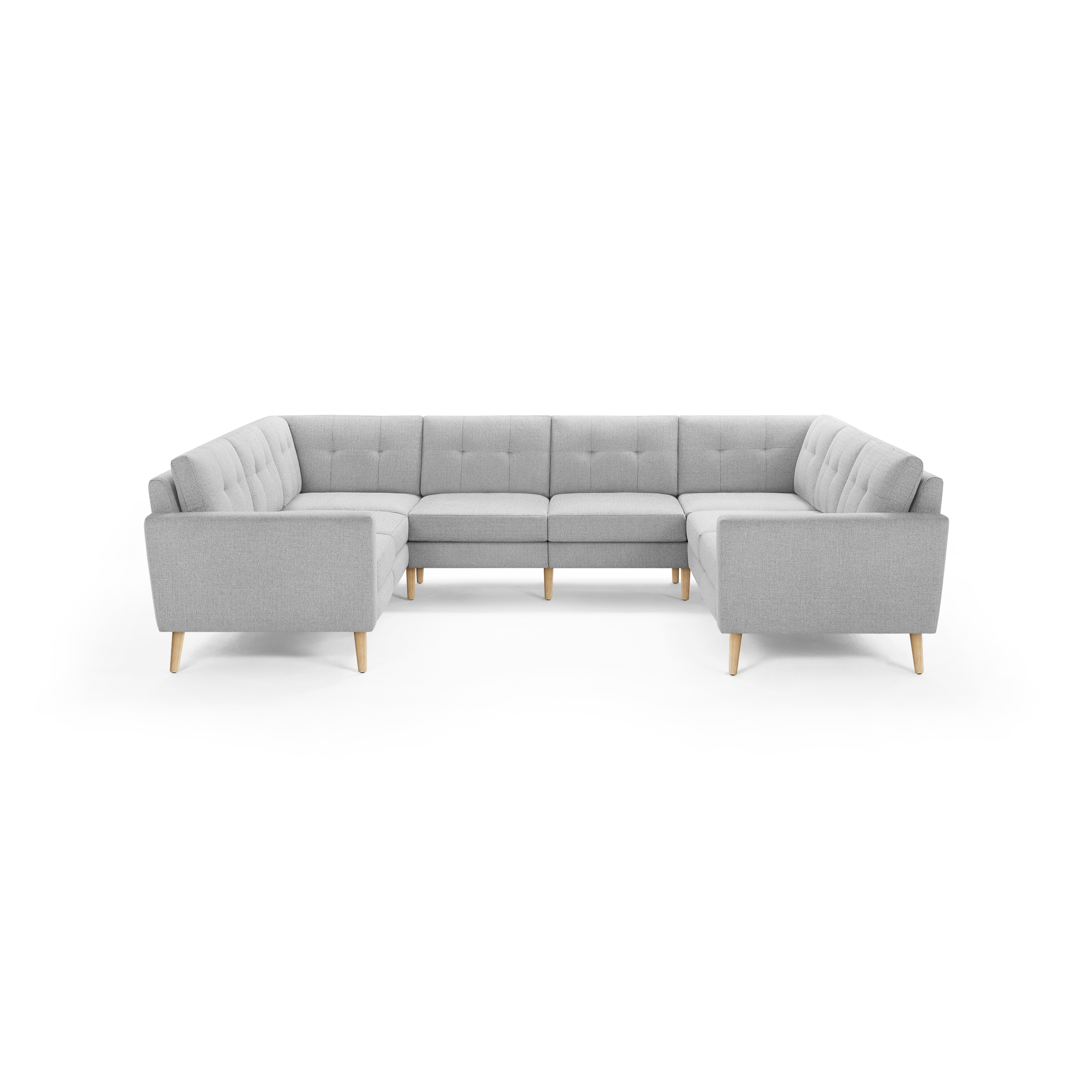 Light gray upholstered U-shaped sectional sofa with tufted back cushions and natural wood tapered legs on black background.