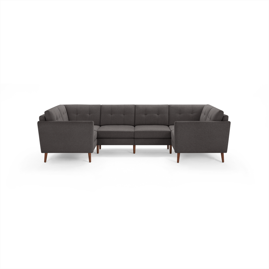 Dark gray upholstered sectional sofa with tufted back cushions, straight arms, and wooden legs, arranged in a U-shape.