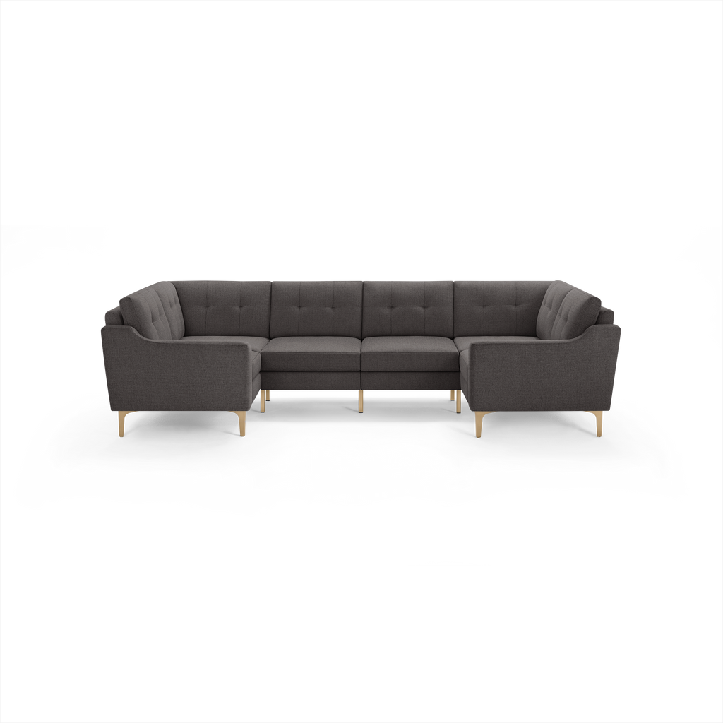 Dark gray upholstered L-shaped sectional sofa with tufted back cushions and light wooden legs.