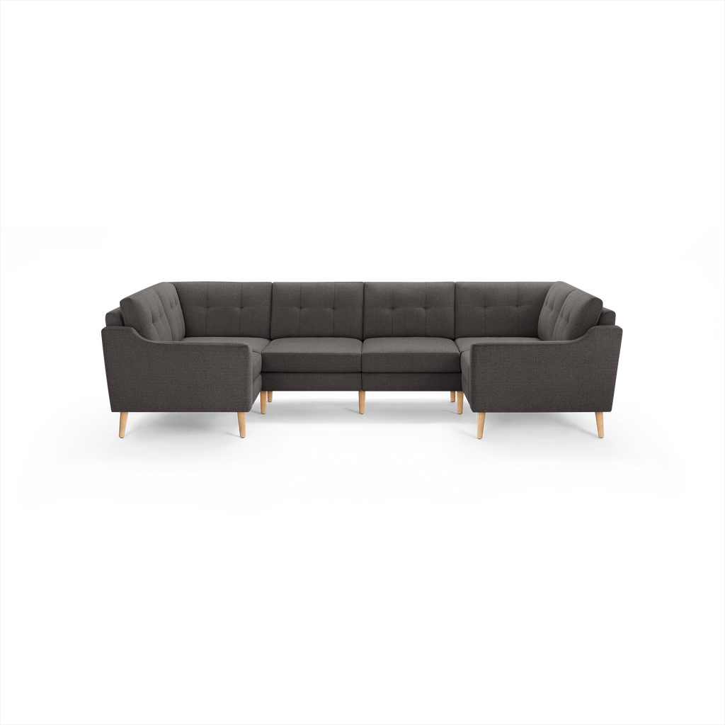 Dark gray L-shaped sectional sofa with tufted cushions and light wooden legs, designed for spacious seating.