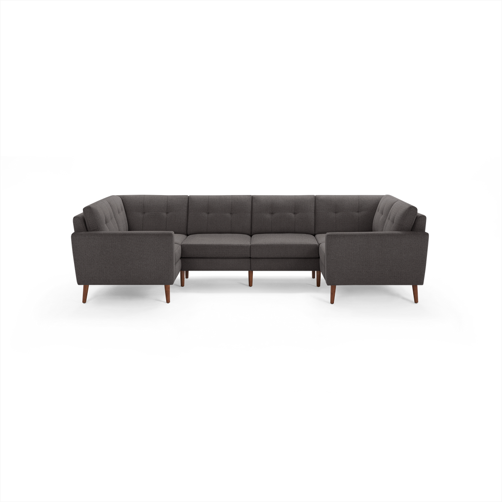 Dark gray fabric L-shaped sectional sofa with tufted back cushions and wooden legs, modern mid-century design.