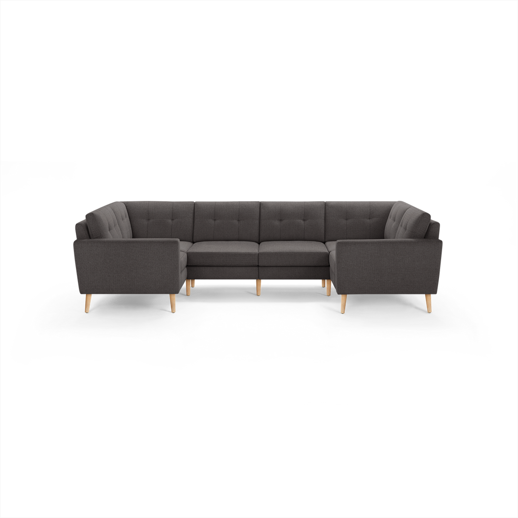 Dark gray upholstered U-shaped sectional sofa with tufted back cushions and natural wood legs, modern and spacious for living room seating.