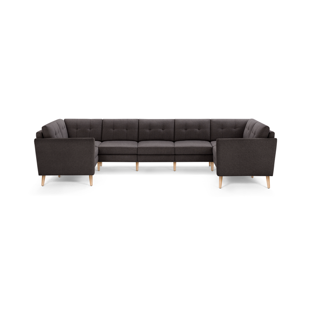 Large modern dark gray fabric sectional sofa with tufted back cushions and light wood tapered legs.