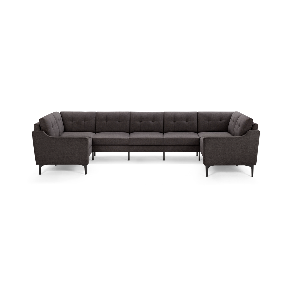 Large dark gray fabric sectional sofa with tufted back cushions, modern clean lines, and slender black legs, forming a U-shape.
