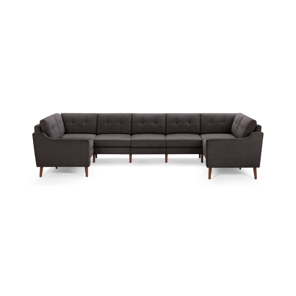 Dark gray fabric U-shaped sectional sofa with tufted back cushions and tapered wooden legs.