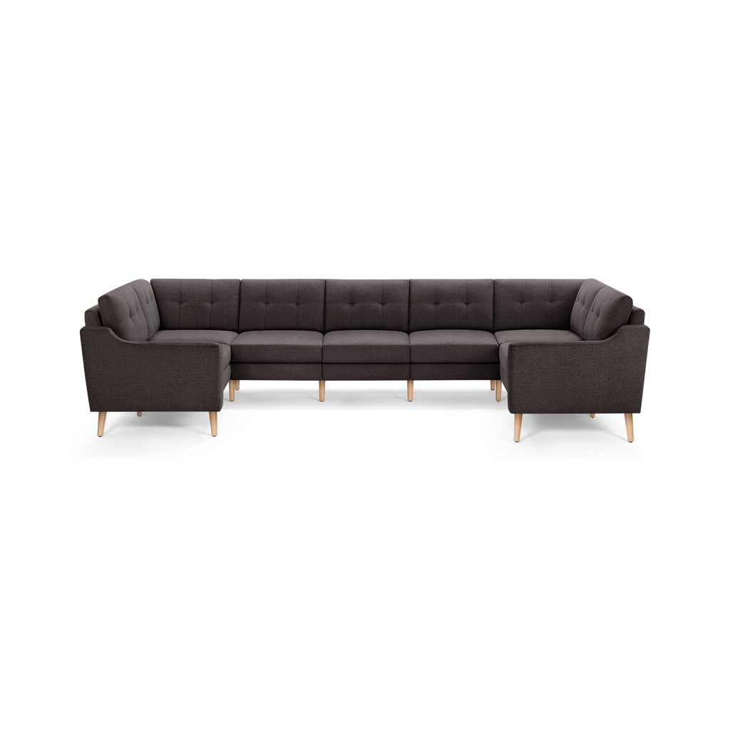Dark gray fabric upholstered U-shaped sectional sofa with tufted back cushions and light wooden tapered legs.