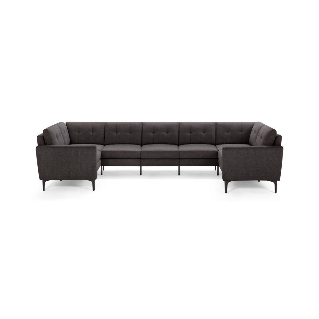 Dark gray fabric U-shaped sectional sofa with tufted cushions, slim armrests, and modern angled black legs.
