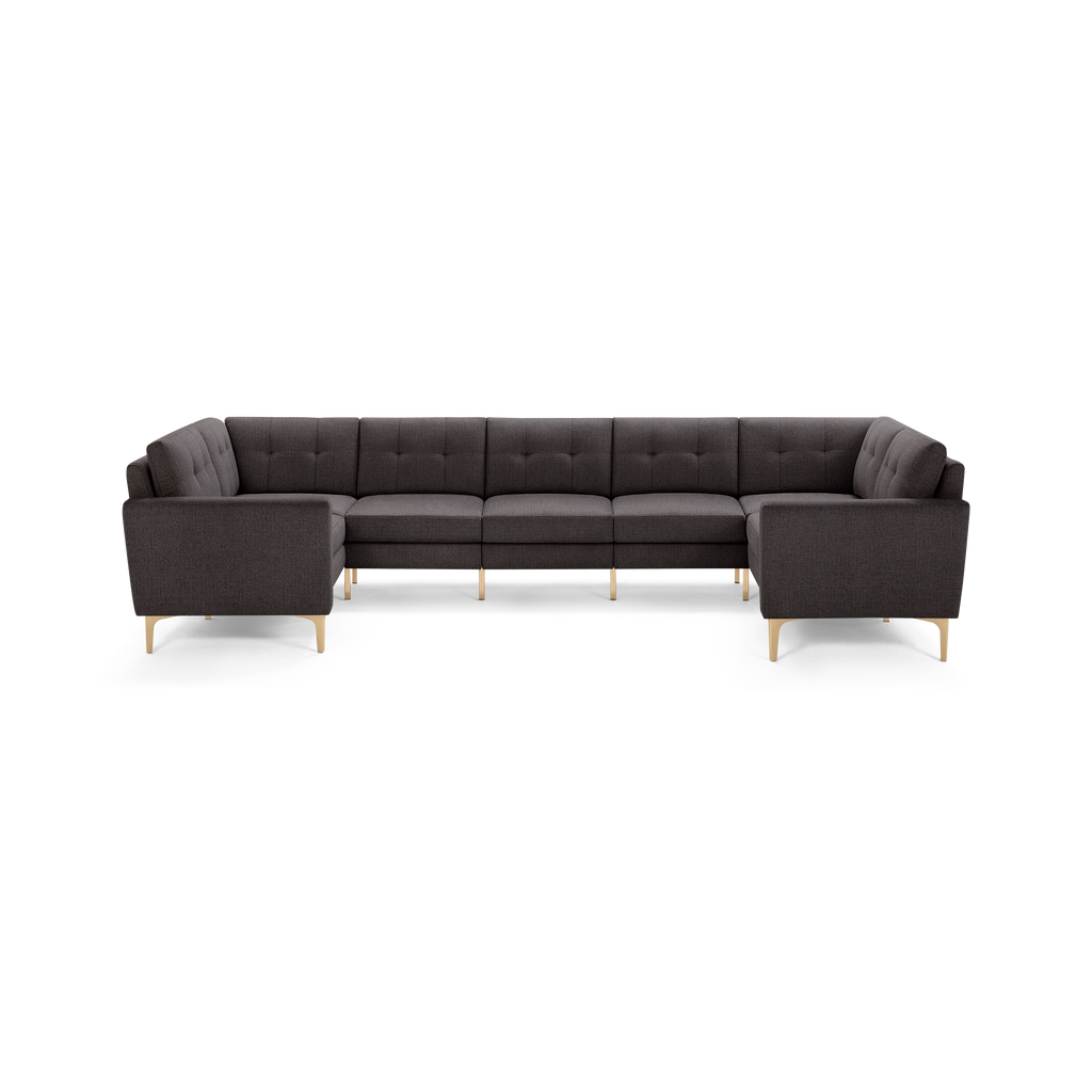 Dark gray fabric sectional sofa with tufted back cushions, straight armrests, and light wooden legs in a U-shaped design.
