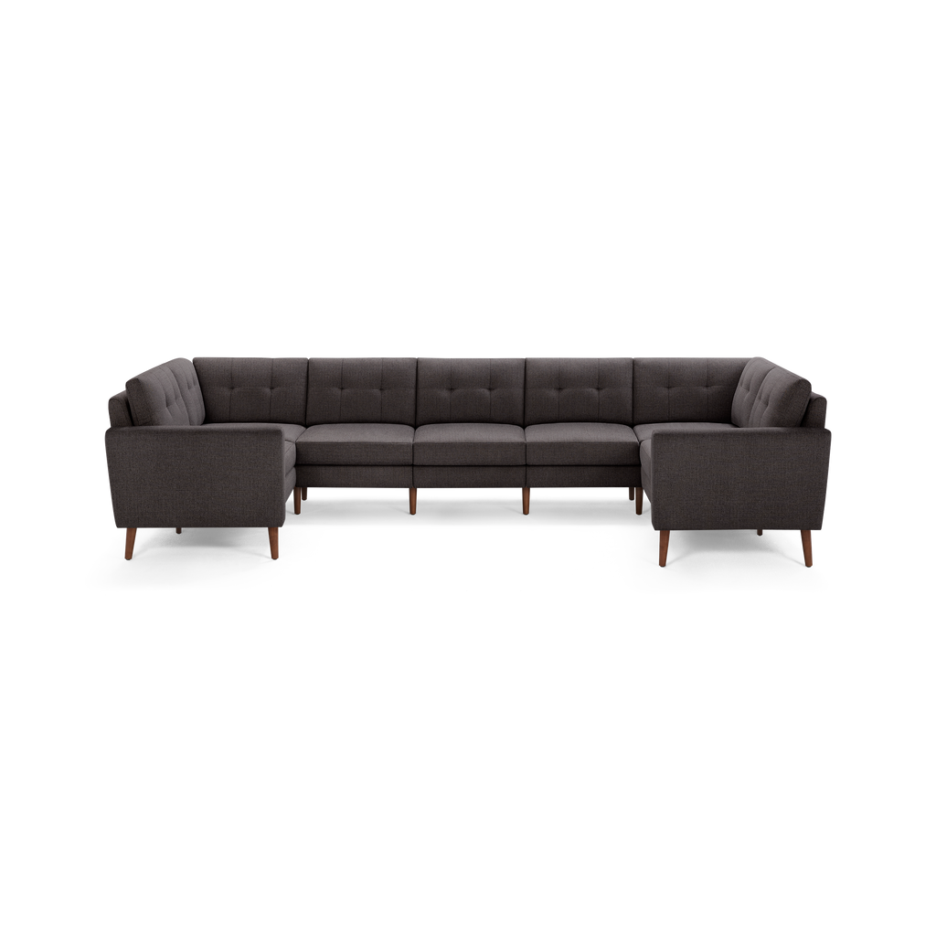 Dark gray upholstered sectional sofa with tufted back cushions and wooden legs, arranged in a U-shaped configuration.