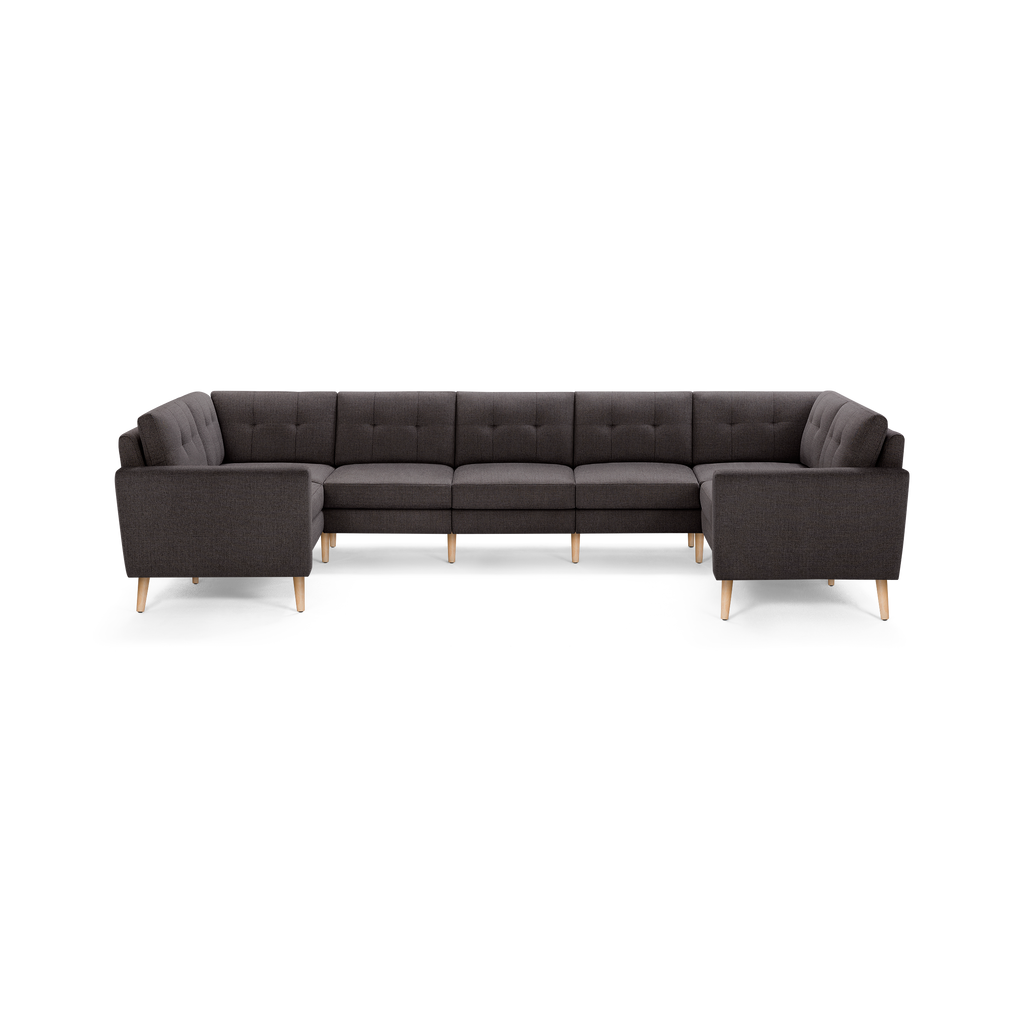 Dark gray L-shaped sectional sofa with tufted back cushions and light wooden legs, modern and spacious.