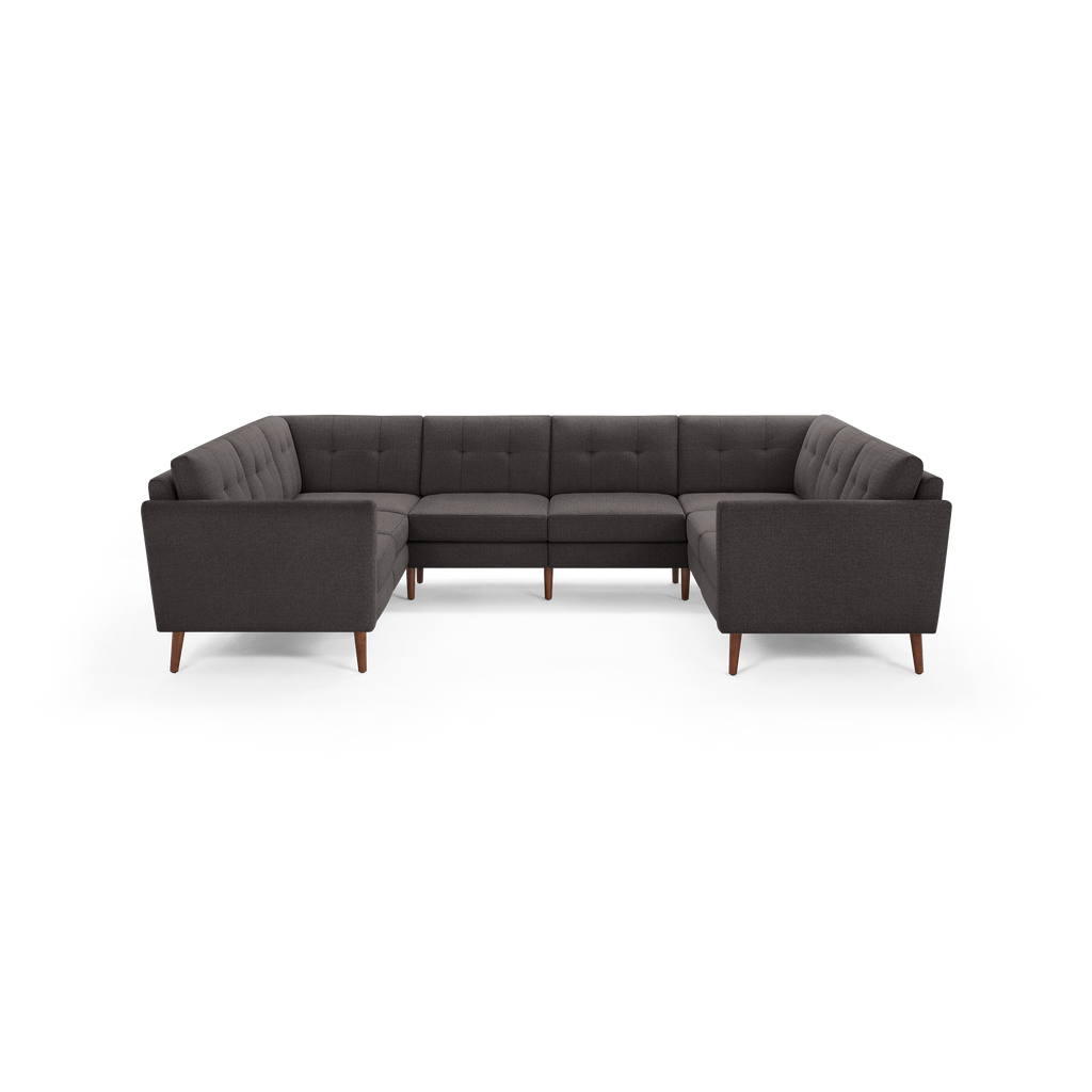 Dark gray fabric U-shaped sectional sofa with tufted back cushions and wooden tapered legs, modern mid-century design.