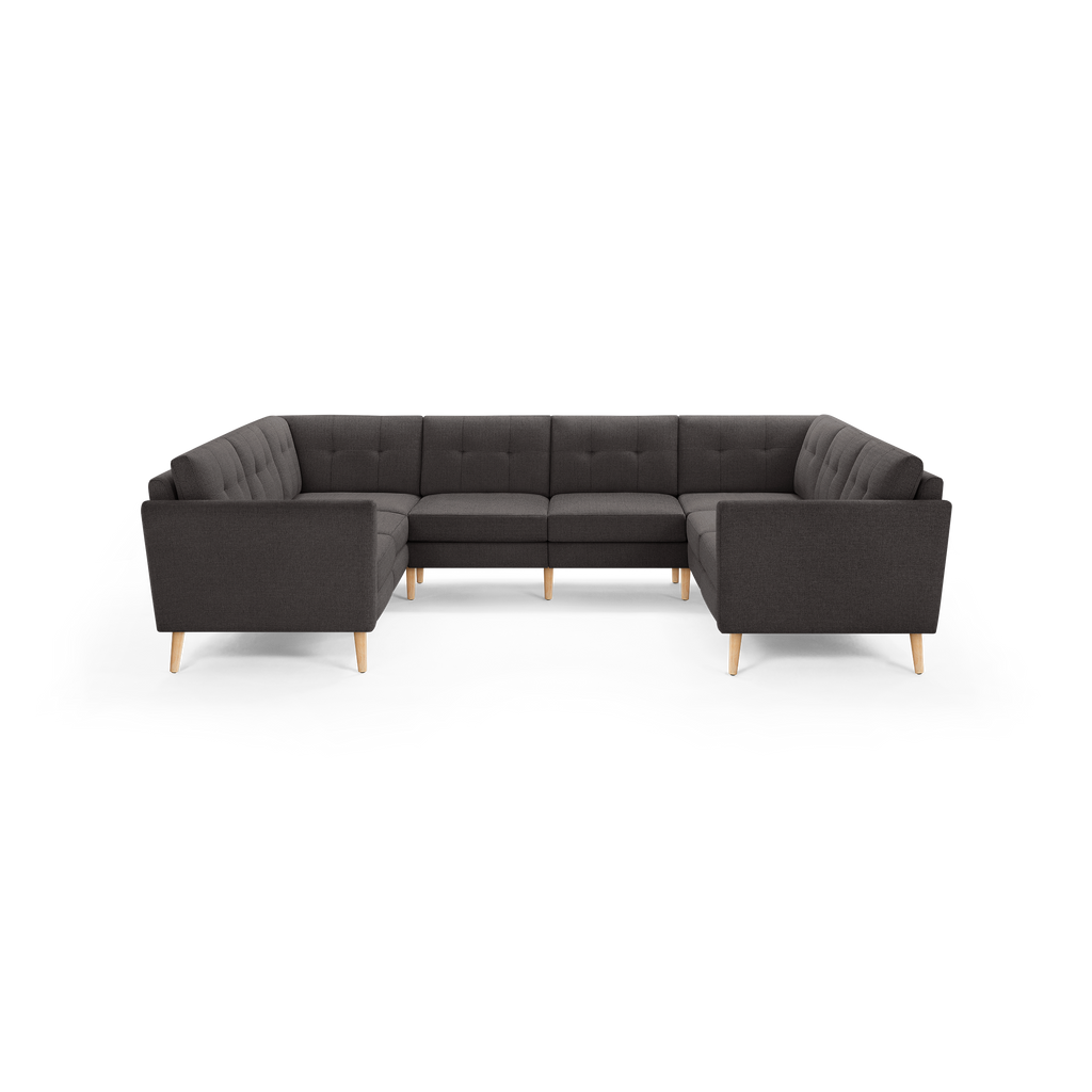 Dark gray fabric U-shaped sectional sofa with tufted back cushions and light wooden legs.