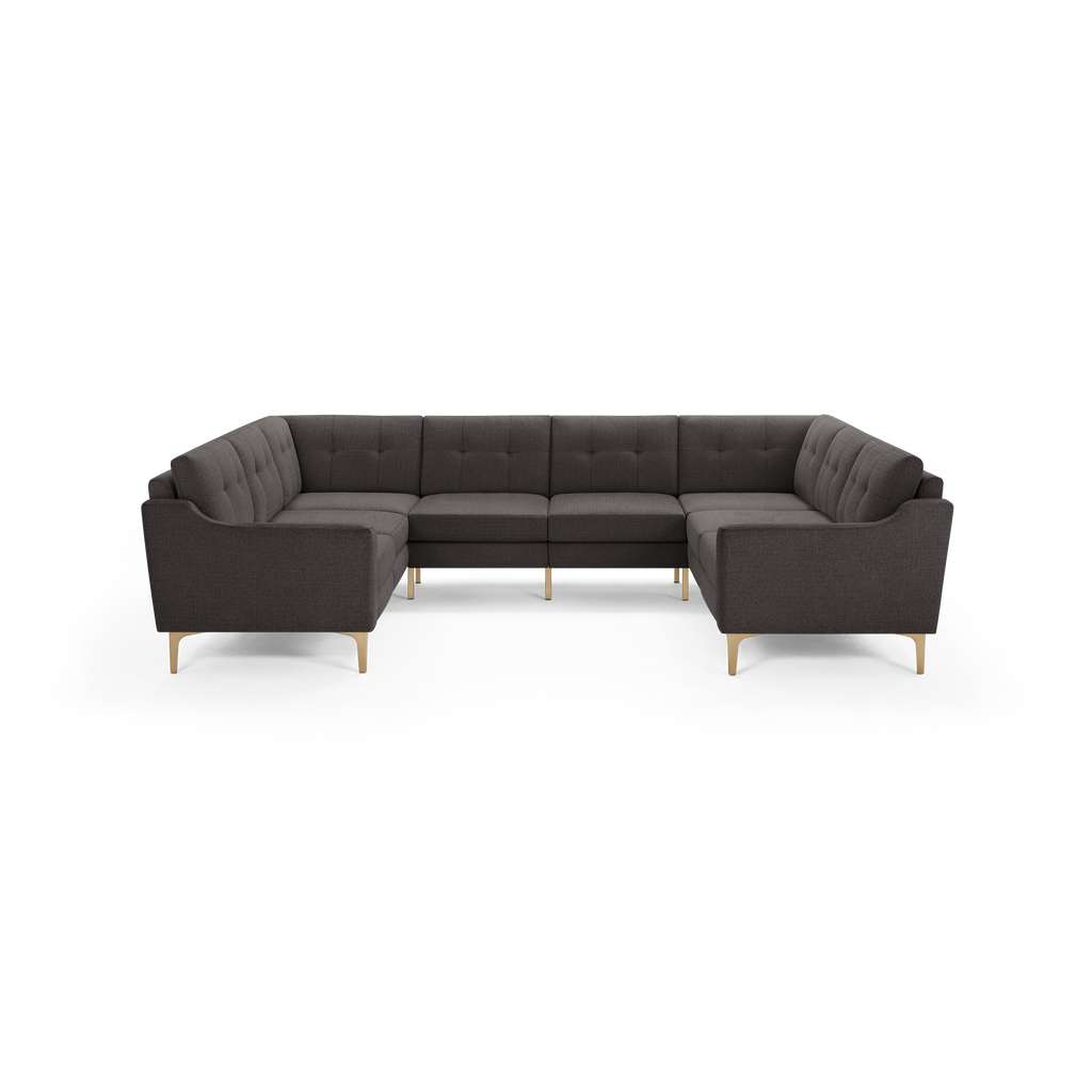 Dark gray upholstered U-shaped sectional sofa with tufted back cushions and light wooden legs.