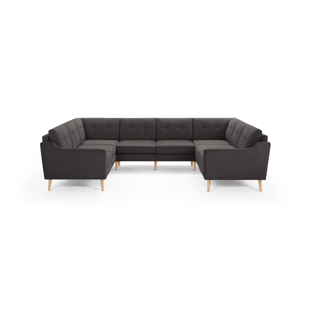 Dark gray fabric U-shaped sectional sofa with button-tufted back cushions and light wooden angled legs.