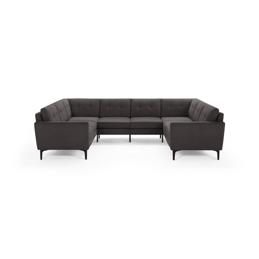 Dark gray upholstered modern sectional sofa with tufted back cushions and slim black metal legs, arranged in U-shape.